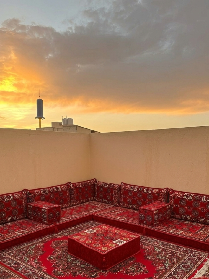 Brocade-Muster auf rotem Sitzkissen und Teppich, Terrasse mit Blick auf den Sonnenuntergang, Majlis-Home Marke